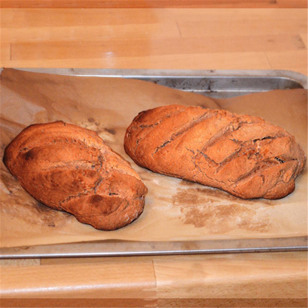 Du pain fait maison sur une plaque de cuisson est sorti du four. Pain long,  baguette à la maison dans la cuisine. Produits de boulangerie. Faites cuire  à la maison Photo Stock 